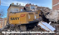 Ağır hasarlı binanın enkazı iş makinesinin üstüne yıkıldı